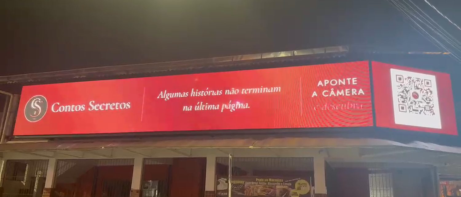 Painel de LED horizontal na R. Ipiranga, Centro de São Vicente, aceso à noite